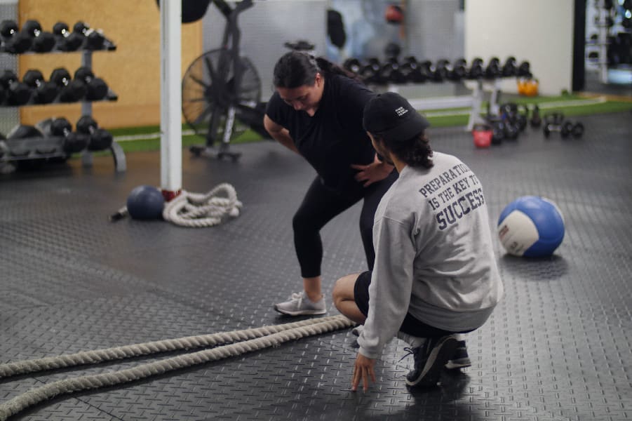 personal trainer directing woman
