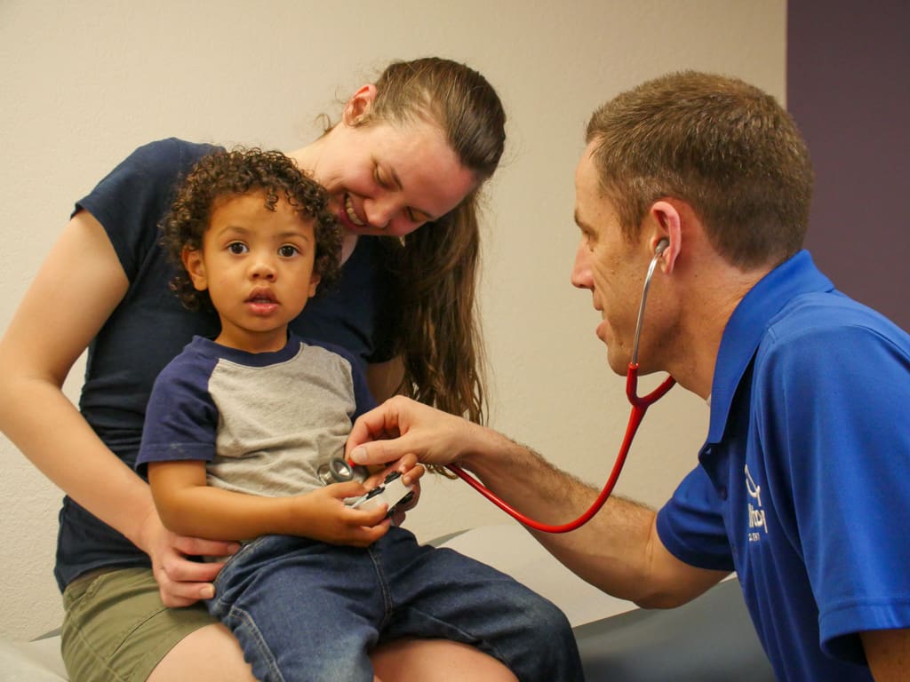 Pediatrician listening to child's heart
