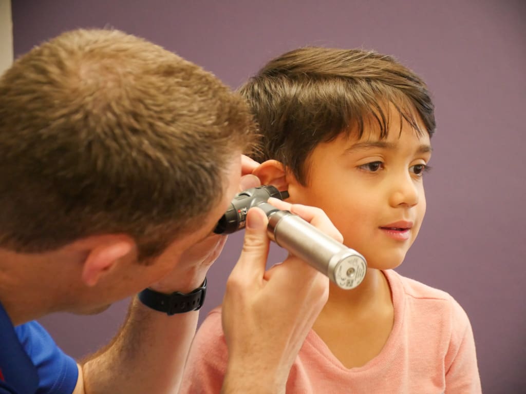 pediatrician looking into child's ear